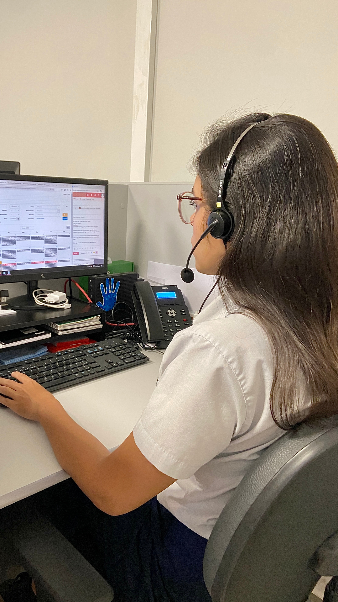 Telefonista SLG com headset em atendimento ao cliente