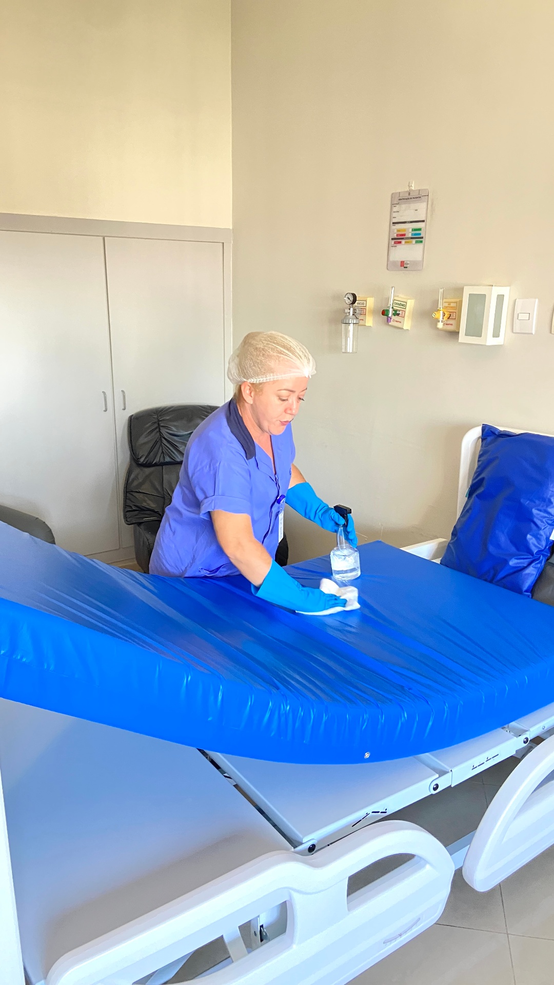 Profissional SLG realizando desinfecção de maca hospitalar