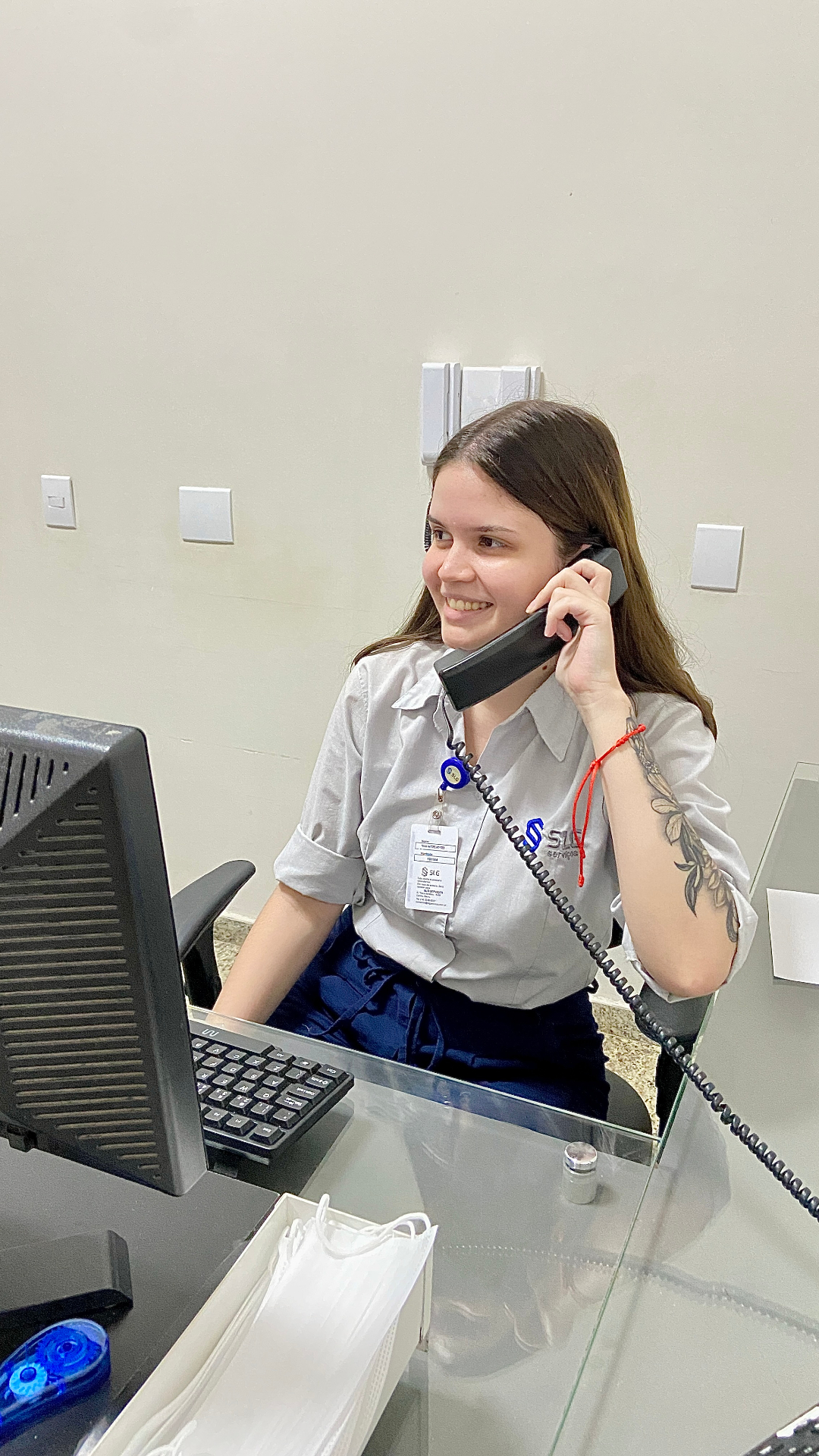 Telefonista SLG em recepção atendendo telefone