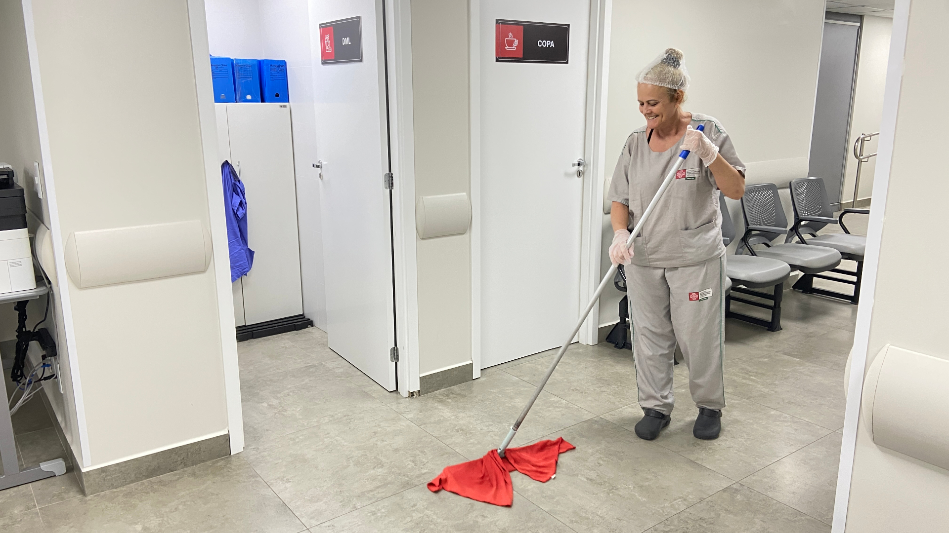Colaboradora SLG realizando limpeza de área administrativa